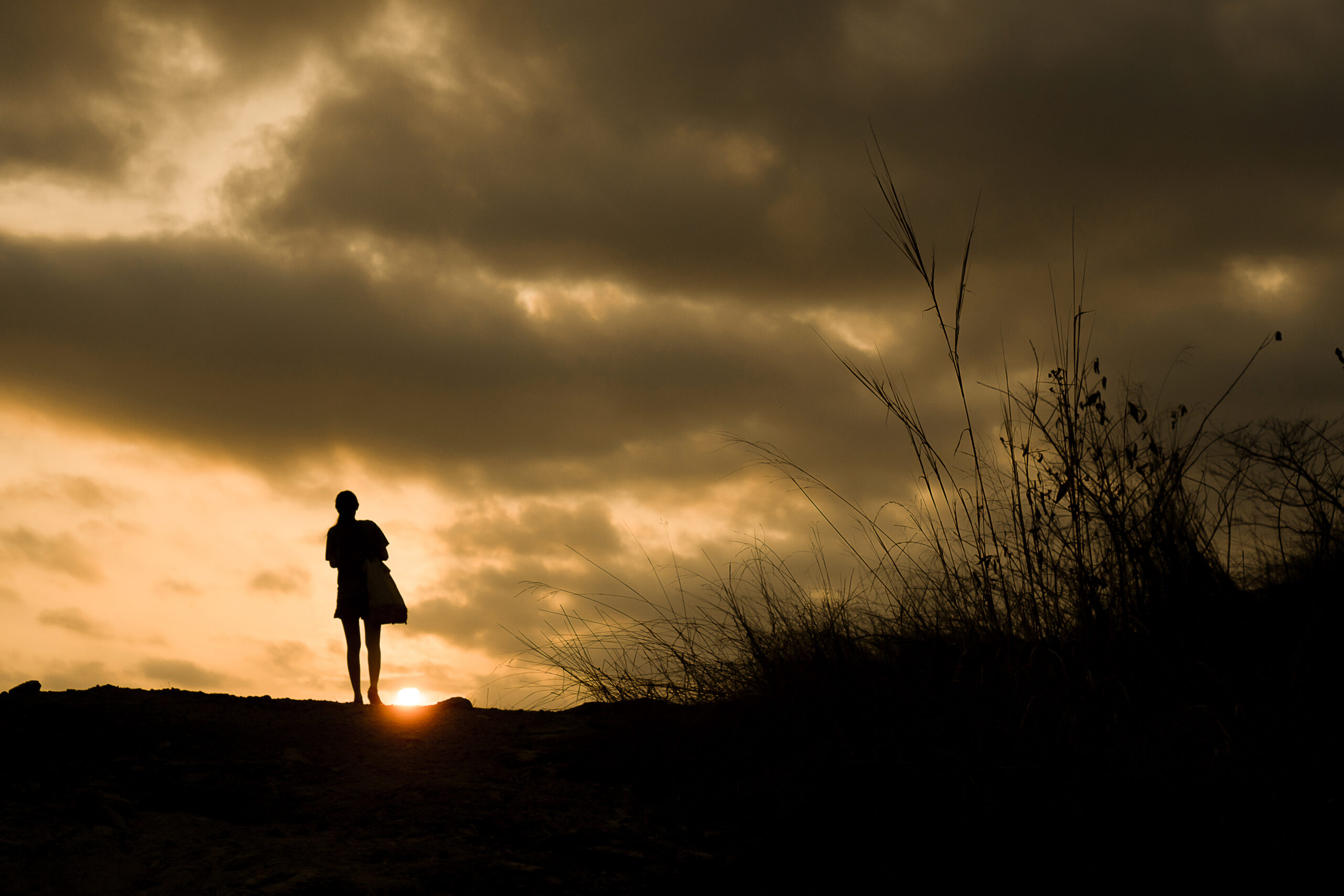 Silhouette of a person walking with sunset