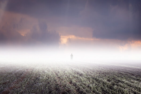 Silhouette of man standing in distant fog