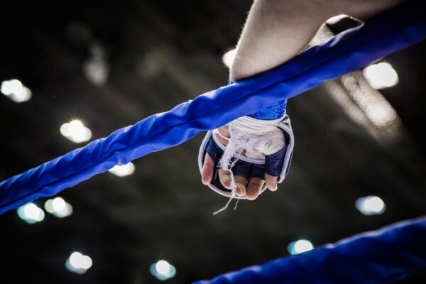Hand of fighter on ropes of ring during competition in mixed martial arts