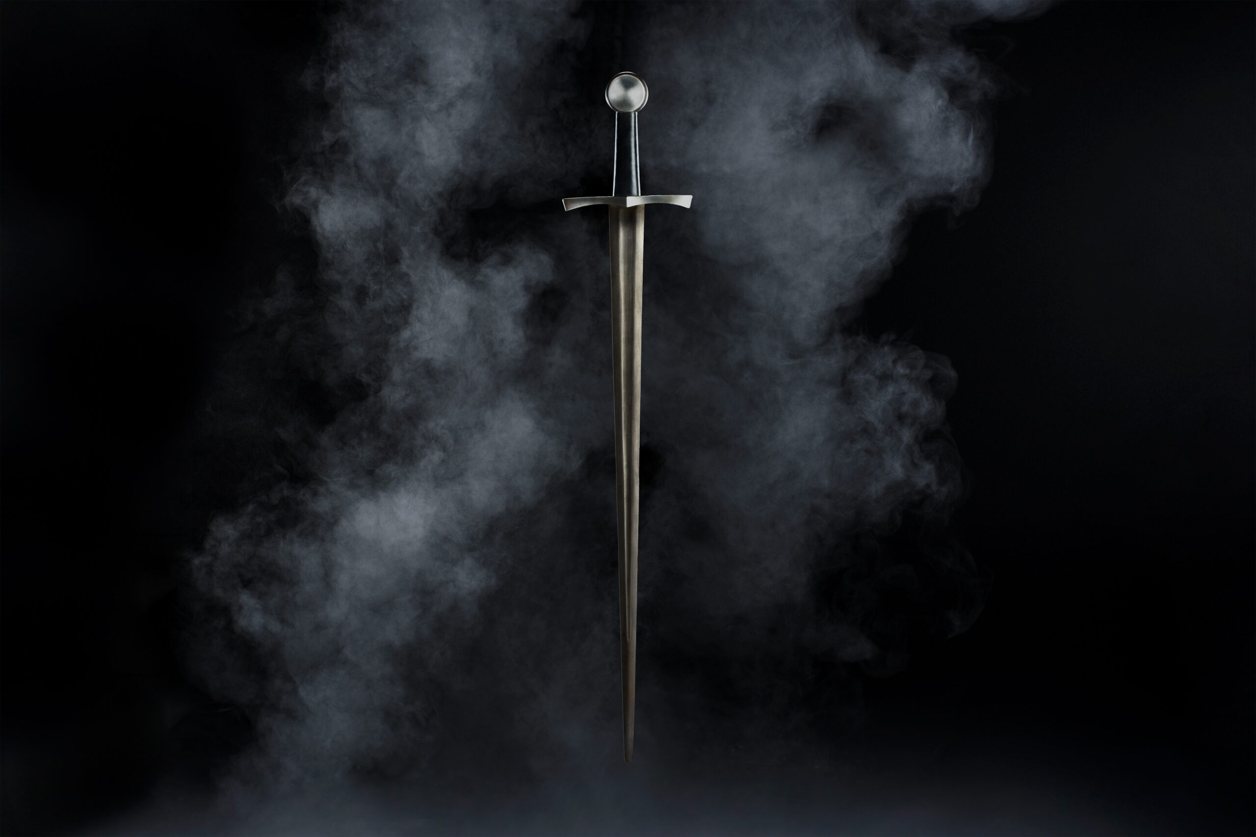 A vertical shot of a sword isolated on a black background