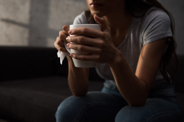 Cropped view of woman holding cup of coffee