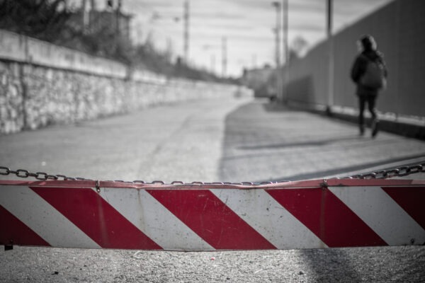 A girl walking down the street, toward the school.